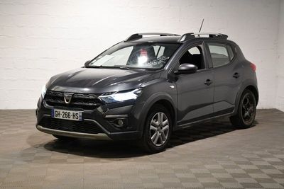 la voiture grise est garée dans une grande pièce au sol en damier