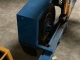 a small blue truck with a fork attached to the back of it