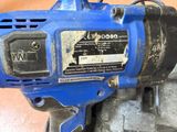 an image of a blue electric driller on a wooden floor