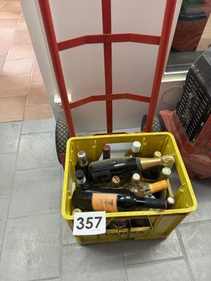 bottles of wine are in a yellow basket on the floor
