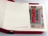 un livre ouvert avec une couverture rouge sur laquelle figure l'image d'un tableau