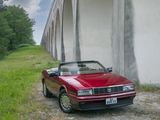 a red car that is parked in front of a wall