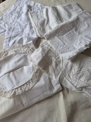 une chemise blanche et un pantalon blanc posés sur un lit