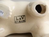 a white ceramic pig with a tag on it ' s side