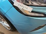 a blue car with a sticker on it ' s front bumper
