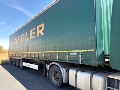 un gros camion vert garé sur le bord de la route
