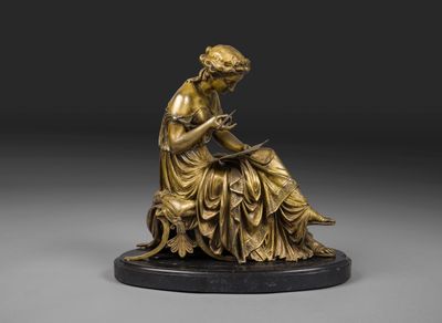 une statue en bronze représentant une femme assise sur un rocher