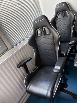 deux fauteuils de course noirs et blancs dans un coin de la pièce