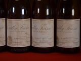 six bottles of wine are lined up on a red table