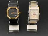 Deux montres sont posées côte à côte sur une surface noire