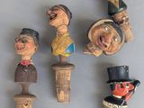 cinq figurines en bois représentant différentes personnes, posées sur une table