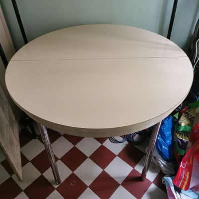 une table au plateau blanc posée sur un sol à carreaux rouges et blancs