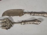 two silver spoons and a knife on a table