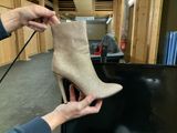 someone is holding a pair of high heeled boots in their hand