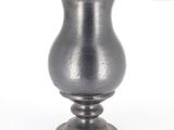 a silver vase that is sitting on a table