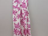 a white and pink dress hanging on a hanger next to a teddy bear