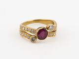 gros plan d'une bague en or avec un rubis et des diamants