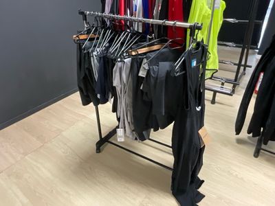 un portemanteau dans un magasin de vêtements, sur lequel sont suspendus des vêtements