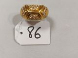 gros plan d'une bague en or sur une surface blanche