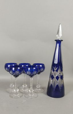 four wine glasses and a decanter on the table