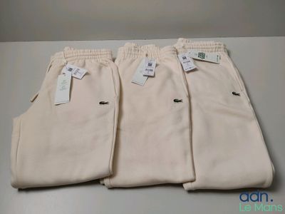 trois paires de pantalons de sport blancs pour homme, avec leurs étiquettes encore attachées