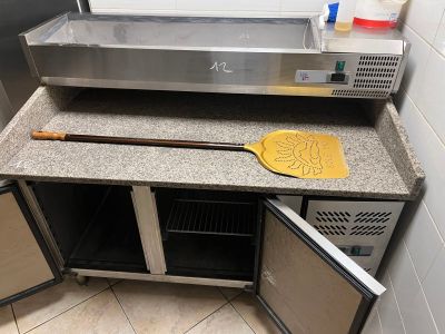 a counter with a pizza oven and a pizza paddle on it