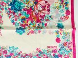 a close up of a pink and blue floral scarf on a white surface