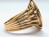 a close up of a gold ring on a white surface
