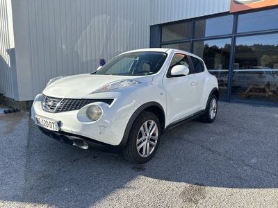 La Nissan Juke blanche est garée devant un immeuble.