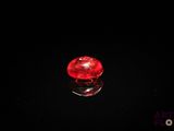 un gros plan d'un objet en verre rouge posé sur une surface noire