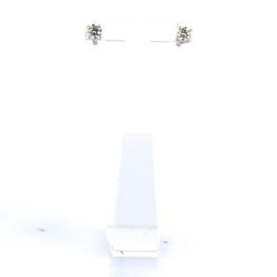 une paire de boucles d'oreilles en diamant posées sur un présentoir, sur fond blanc