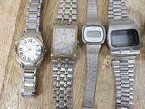 three watches and a watch sitting on a wooden table next to each other