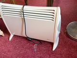a white heater sitting on the floor next to a red chair
