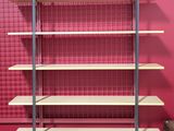 a red wall with a metal shelf and a red wall