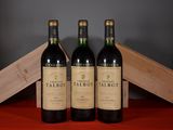 trois bouteilles de vin rouge posées sur une table, à côté d'une caisse en bois