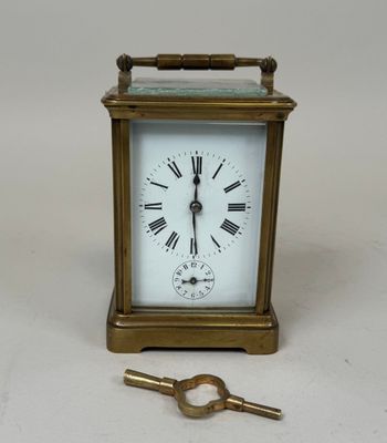 une petite horloge et une clé posées sur une table