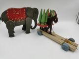 deux éléphants en bois tirant une charrette chargée de sapins de Noël