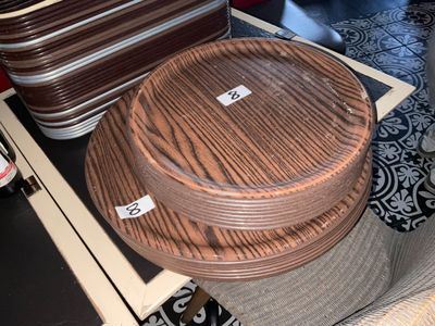 une pile d'assiettes en bois posée sur une table, à côté d'une bouteille de bière