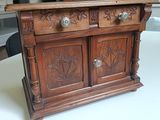 a small wooden cabinet on a table in a room