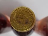 a close up of a bottle of wine with a coin on it