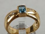 an image of a gold ring with a blue topaz stone