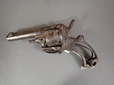 an old silver revolver sitting on top of a white table