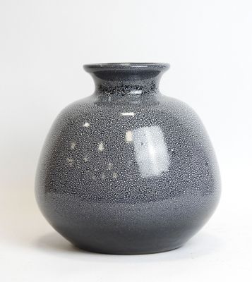 a gray vase sitting on a white surface with a white background