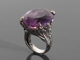a close up of a ring with a purple stone on it