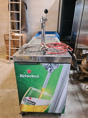 distributeur de bière Heineken dans une cuisine, à côté d'un réfrigérateur
