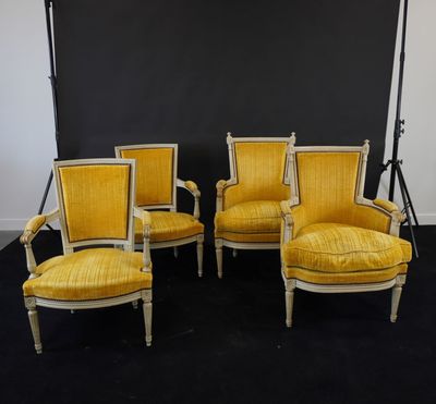 quatre chaises jaunes devant un fond noir dans une pièce