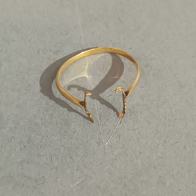 une bague en or à laquelle sont attachées une paire de boucles d'oreilles