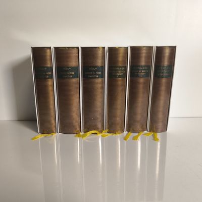 quatre livres sont alignés sur une surface blanche