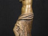 a bronze statue of a woman sitting on a rock