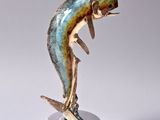 statue of a dolphin on a stand on a white surface